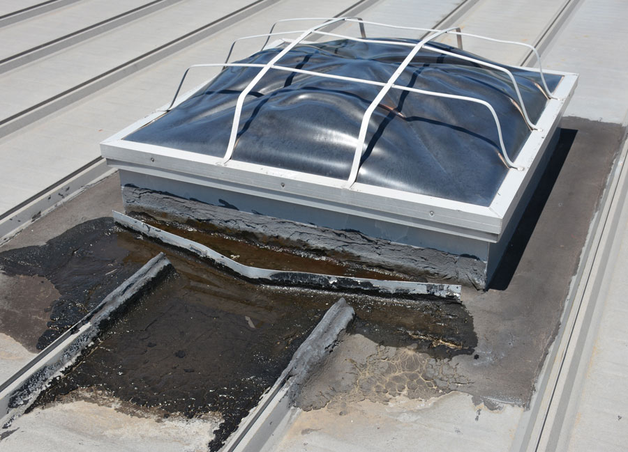 A common material used to repair water leaks, around roof top units, on a metal roof, is tar. This method is very temporary because the tar will dry out and crack very rapidly.