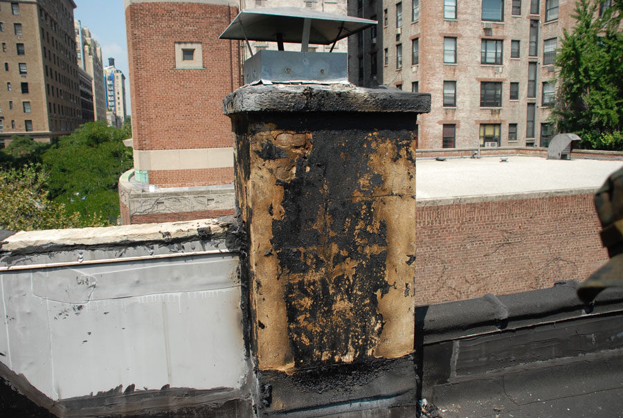 Flat Roof Chimneys and Flashing - This chimney had been continually smeared with tar but the leaking continued.